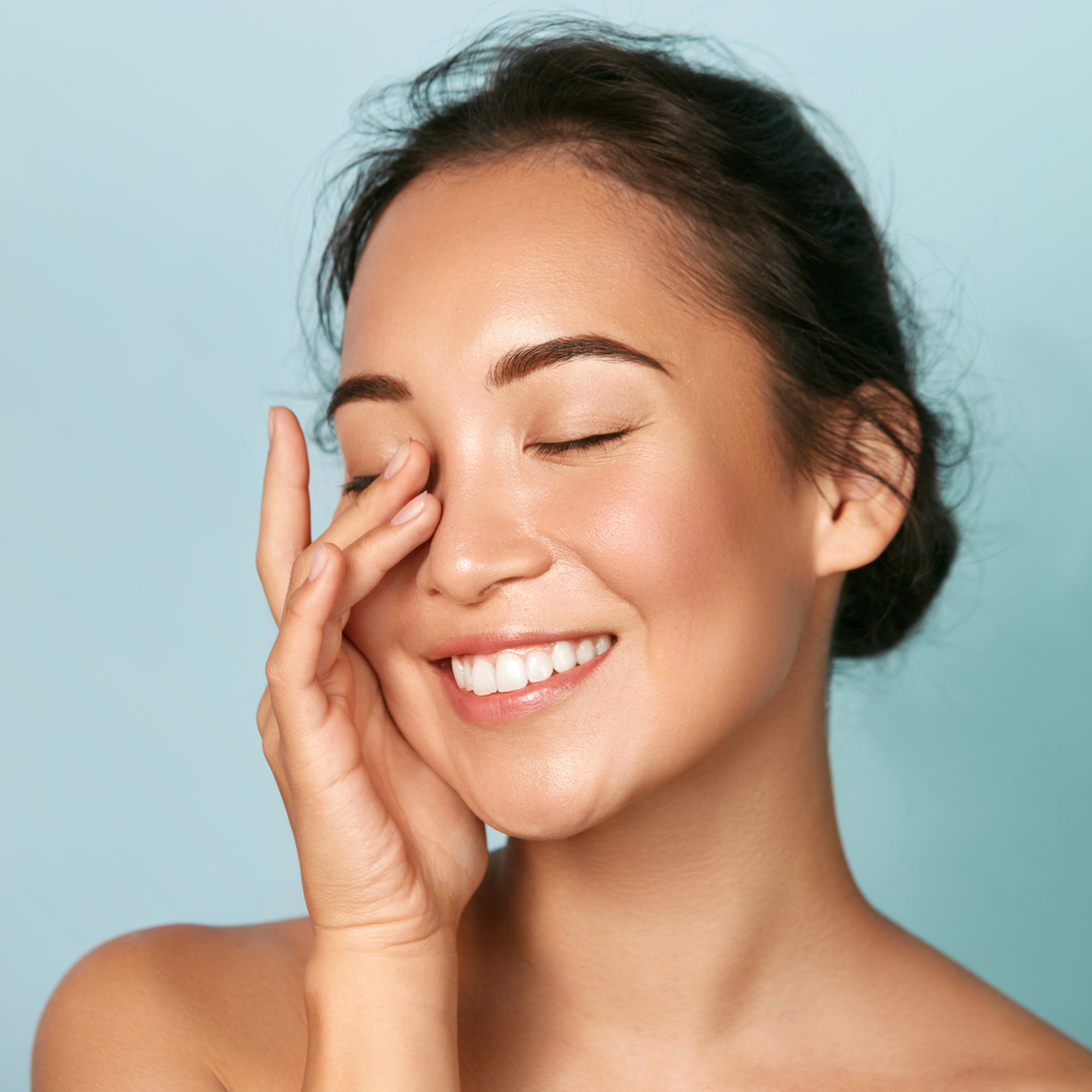 photo d'une femme souriant et se touchant le visage